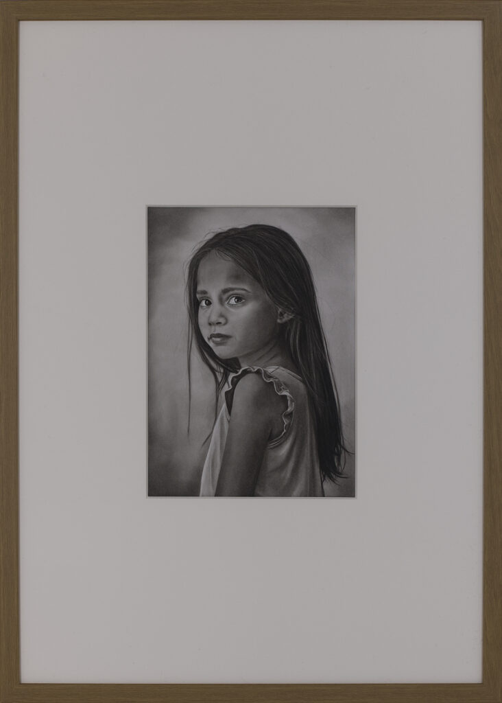 Framed presentation of The First Doubt (2025), a contemporary charcoal portrait by Janis Bär with passepartout and oak frame.