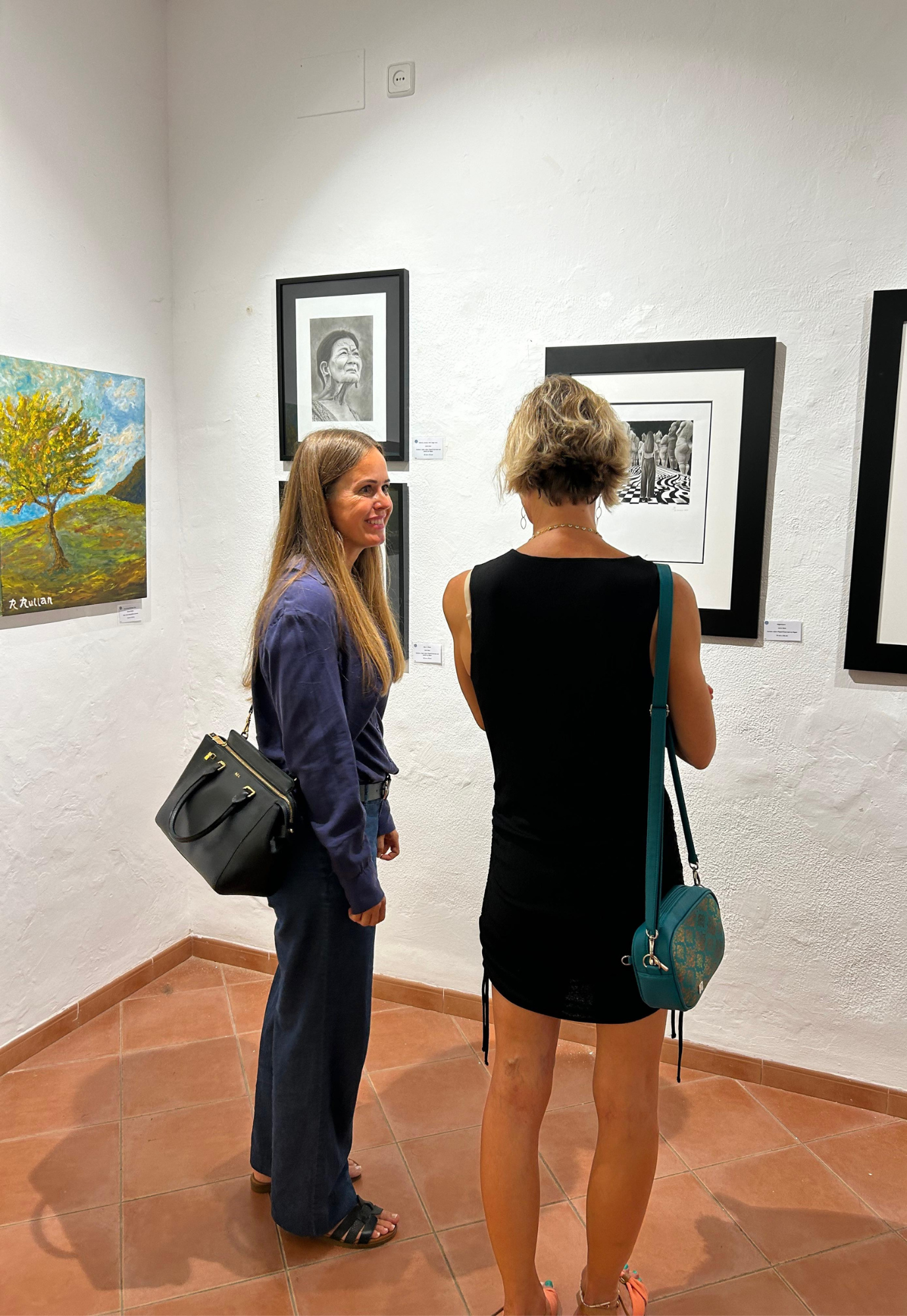 Artist Janis Bär speaking with a visitor during the Artists of Mallorca Autumn Exhibition 2025 at Museu de Sóller, Mallorca.