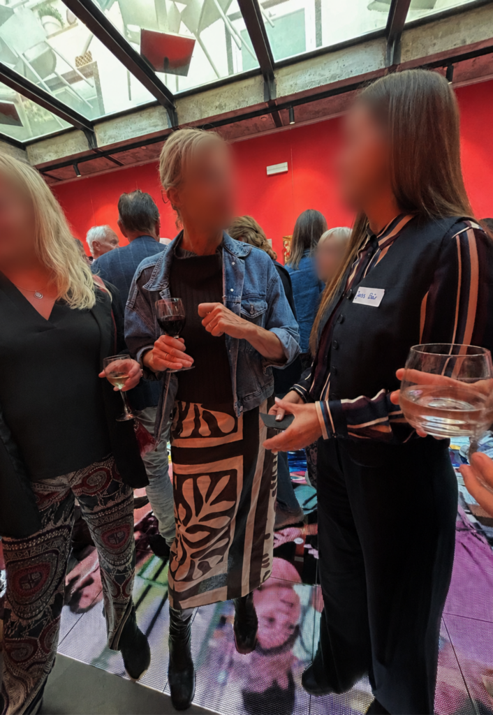 Artist Janis Bär speaking with visitors during the ART for a Good Reason charity exhibition at Gallery Hotel Artmadams in Palma, Mallorca.